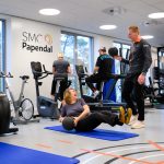 Fysiotherapeut begeleidt patiënt tijdens oefentherapie Fysiotherapeut begeleidt patiënt tijdens oefentherapie